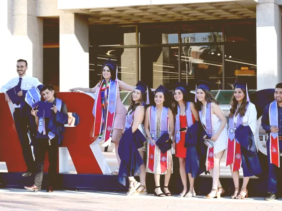 Graduating Students celebrating in front of Bear Down