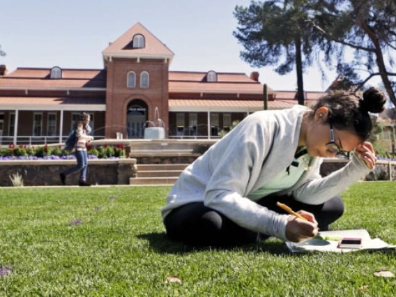 Welcome 2025 - Student on lawn in front of Old Main