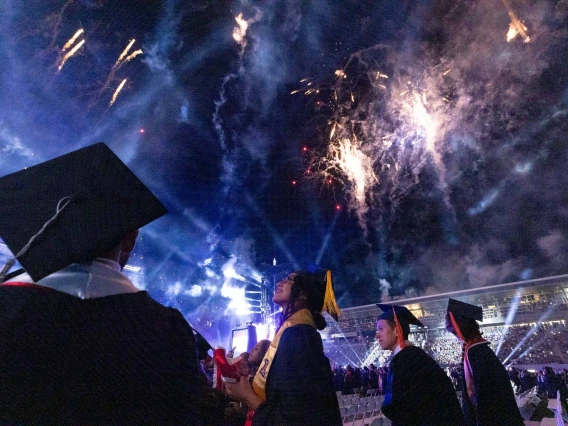 Students at Graduation with Fireworks overhead.