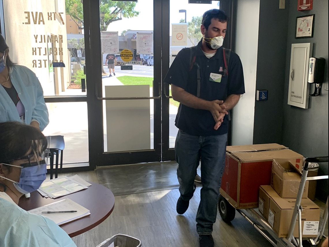 Collin Rogow brings a load of equipment into a Valleywise Community Health Center in Phoenix