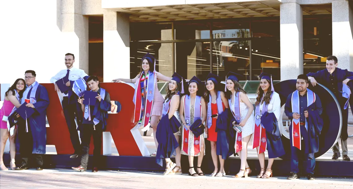 Graduating Students celebrating in front of Bear Down