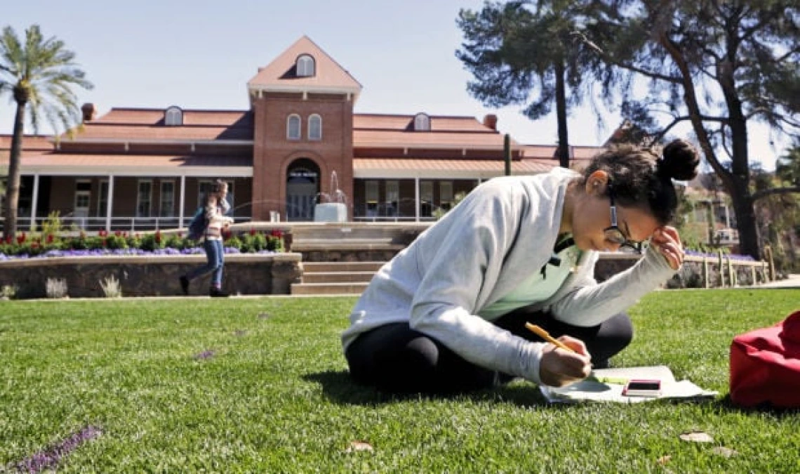 Welcome 2025 - Student on lawn in front of Old Main