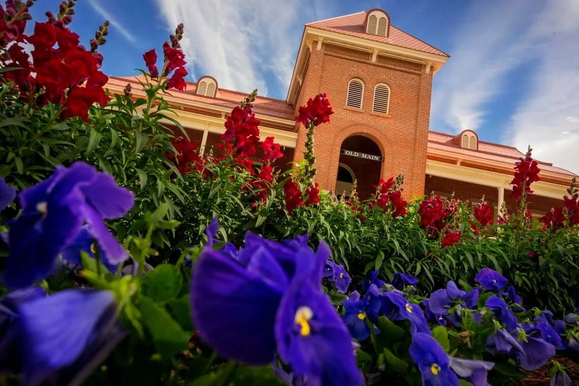 Old Main with Flowers in the foreground.